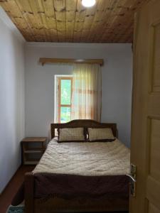 a bedroom with a large bed with a window at Otisha Guesthouse in Tsaldashi