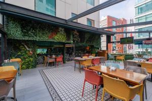 a restaurant with tables and chairs and a green wall at Park Inn by Radisson Istanbul Asia Kavacik in Istanbul