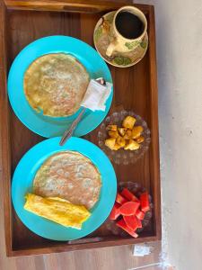 a tray with three plates of food and a cup of coffee at AWAN Homestay in Kuta Lombok +15 photos