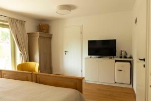 a bedroom with a bed and a television on a cabinet at Macskalépcsős Boutique B&B in Dörgicse