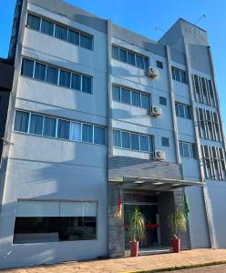ein Gebäude mit zwei Topfpflanzen davor in der Unterkunft Hotel Comoditá Ltda in Sapiranga