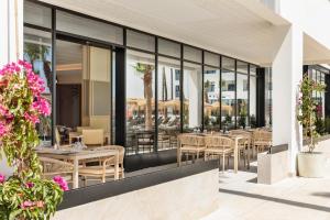 ein Restaurant mit Tischen, Stühlen und Fenstern in der Unterkunft Hotel Best Mojácar in Mojácar