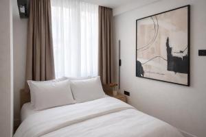 a bedroom with a white bed and a window at Sky Panorama in Soko Banja