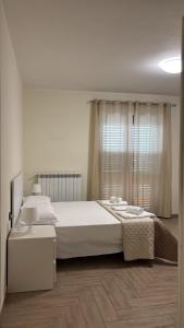 a bedroom with a large white bed and a window at B&B Dimora Elmara in San Salvo