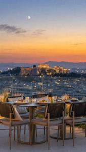 a table and chairs on a roof with a view at St George Lycabettus Lifestyle Hotel in Athens