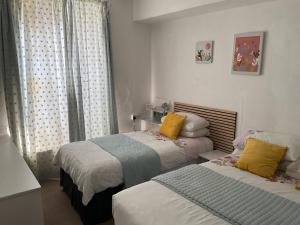 a bedroom with two beds and a window at Admiralty House in Weymouth