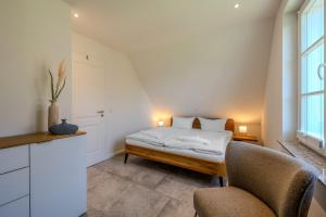 a bedroom with a bed and two chairs at Traumgarten Traumzeit in Prerow