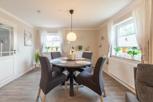a dining room with a table and chairs at Jule Ahoi in Stedesand