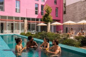 a group of people sitting in a swimming pool at Password to Madrid Casa de Campo in Madrid