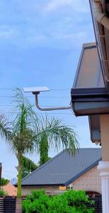 a security camera on top of a building with a palm tree at Paradise Creek Hotel in Tamale +1 photo