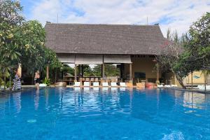 a resort with a swimming pool with a building at Maruti Beach Villas in Nusa Penida