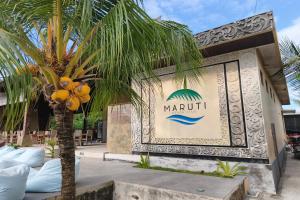 a sign for a marriott resort next to a palm tree at Maruti Beach Villas in Nusa Penida