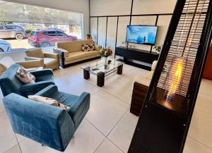 ein Wohnzimmer mit Sofas und einem Flachbildfernseher in der Unterkunft Hotel Comoditá Ltda in Sapiranga