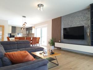 a living room with a couch and a tv on a wall at Villa Mihojka in Malinska