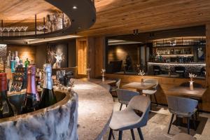 a restaurant with tables and chairs and a bar at Hotel Crozzon in Madonna di Campiglio