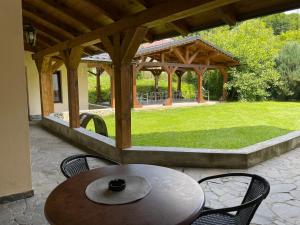 a patio with a table and chairs and a gazebo at Gama House & Garden with restaurant in Vişeu de Sus