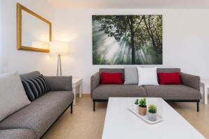 a living room with two couches and a table at GuestReady - Tarantos Sea View and Pool in Playa del Ingles