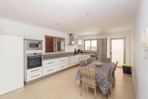 a kitchen with a table and chairs and a kitchen with white cabinets at GuestReady - Tarantos Sea View and Pool in Playa del Ingles