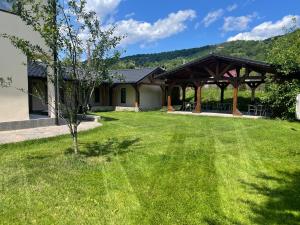 a yard with a gazebo and a tree at Gama House & Garden with restaurant in Vişeu de Sus