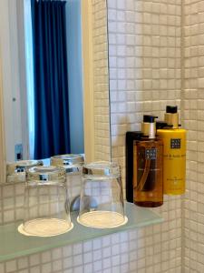 a shelf with three glass jars and a mirror at Maritim Hotell & Krog in Simrishamn +42 photos