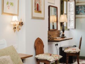a living room with a chair and a table and mirror at La Casa 1832 Boutique in Sanlúcar de Barrameda