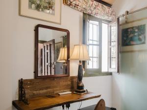a mirror and a lamp on a table in a room at La Casa 1832 Boutique in Sanlúcar de Barrameda