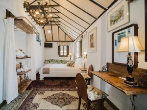 a bedroom with a bed and a desk with a lamp at La Casa 1832 Boutique in Sanlúcar de Barrameda