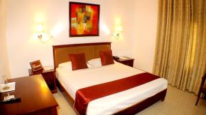 a hotel room with a bed and a table at Hotel Residence Flamani in Lomé