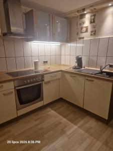 a kitchen with white cabinets and a stove top oven at Justyna-Sebastian FE-WO in Paderborn