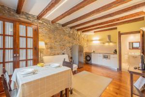 a living room with a table and a stone wall at Zelaikoa Behekoa - baskeyrentals in Zestoa