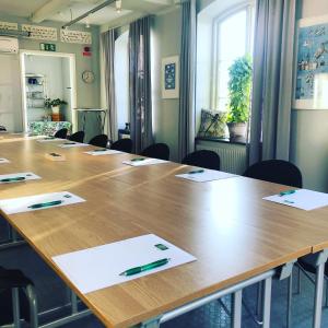 a conference room with a large wooden table with pens on it at Maritim Hotell & Krog in Simrishamn