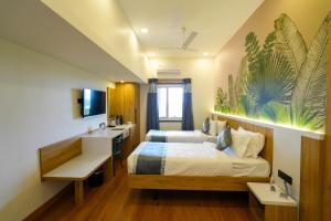 a bedroom with a bed and a desk and a sink at MGM Vailankanni in Velankanni +90 photos