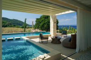 a swimming pool with a patio with a table and chairs at Kappa Resort in Paliouri