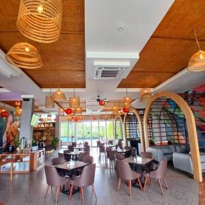 a restaurant with tables and chairs in a room at Grand Central Medan in Medan