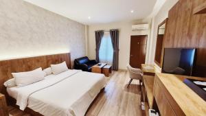 a hotel room with a bed and a television at Grand Central Medan in Medan