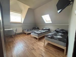 a room with two beds and a table and windows at Noclegi Antoniewo in Morąg
