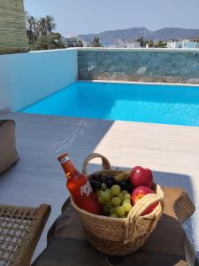 a basket of fruit on a table next to a pool at Milea amare Suites in Adamantas