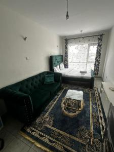 a living room with a green couch and a window at Tsavo in Nairobi