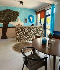 ein Wohnzimmer mit einem Tisch und einem Baumwandbild in der Unterkunft Foinikas Studios in Mérikhas