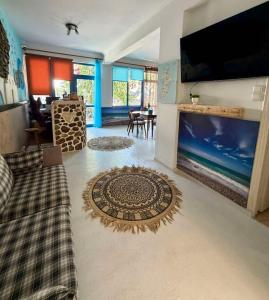 ein Wohnzimmer mit einem großen Fernseher und einem Sofa in der Unterkunft Foinikas Studios in Mérikhas