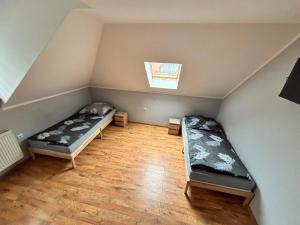 an attic room with two beds and a window at Noclegi Antoniewo in Morąg