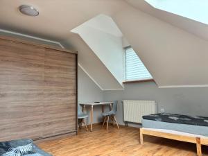 a attic bedroom with a bed and a desk at Noclegi Antoniewo in Morąg