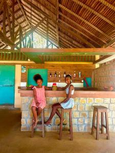 two girls sitting at a counter in a bar at Bungalow Bleu Villa Luna Nosy Be in Nosy Be +31 photos