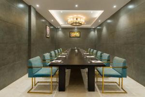 ein Konferenzraum mit einem langen Tisch und blauen Stühlen in der Unterkunft Dazzling A Boutique Hotel in Agra