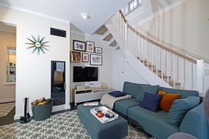 a living room with a blue couch and a staircase at An der See in Dranske