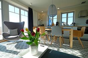 a kitchen and living room with a table and chairs at An der See in Dranske