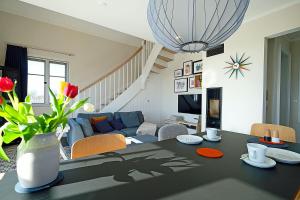 a living room with a table with a vase of flowers at Auszeit am Meer in Dranske