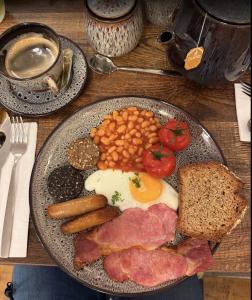 a plate of breakfast food with eggs sausage beans and bread at The Véro Townhouse Killarney in Killarney