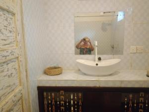a person taking a picture of a sink in a bathroom at Al Mar Bed and Breakfast in Watamu