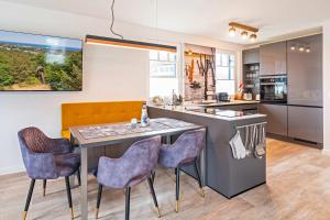 a kitchen with a island with chairs and a counter at Ferienhaus Baltic Huus in Zirchow
